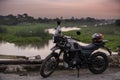 Delhi, New Delhi, India, September 6 2021: A Royal Enfield Himalyan parked on a bridge with a lake view in the background