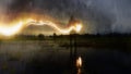 A deliberately blurred, abstract, out of focus, textured edit. Of a ghostly, eerie figure, standing in a flooded field, holding a