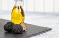 Delicacy mushroom black truffle with olive oil bottle on a light background Royalty Free Stock Photo