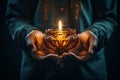 Hands cradling a candle, with its soft, warm glow as the sole source of light, symbolizing the power of a single flame to dispel