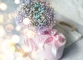 delicate bouquet with pink small flowers and gift box on a wooden white tray. Soft focus,