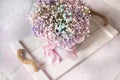 delicate bouquet with pink small flowers on a wooden white tray.