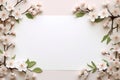 delicate branches of cherry blossoms surrounding a white sheet of paper with a place for text,on a light peach background,a spring Royalty Free Stock Photo