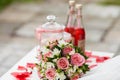 Delicate bride`s bouquet on the table next to red lemonade . Wedding decorations