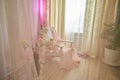 Delicate bright pink interior of the room with armchair, a vase with roses, draped curtains and a window. Location and Royalty Free Stock Photo