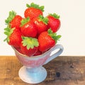 Delicate cup holds a bounty of fresh, luscious strawberries