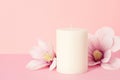 Delicate flower scented candle over pastel pink background with copy space