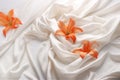 Delicate flowers and petals on a bed of light satin fabric with soft folds and a silky texture
