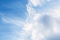 Delicate fluffy cumulus and cirrus clouds against the blue sky. Spring