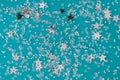 Delicate glitter star confetti on turquoise background. Creative and moody color of the picture