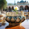 Delicate gold and white flower in an ornamental bowl