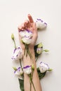 Delicate hand and spring flowers of eustoma are on the white table. Natural cosmetics for hand skin care, a means to reduce Royalty Free Stock Photo