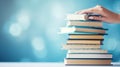 Delicate hands of a woman gracefully cradle a towering stack of books against a soft, light blue background, AI generated Royalty Free Stock Photo