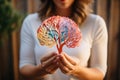 Delicate hands of a woman showcase a model of a diverse human brain, representing the richness of neurodiversity, human