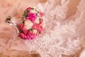 The delicate hem of the bride's dress rests on the light floor. It has ornaments, embroidery and a beautiful bouquet on Royalty Free Stock Photo