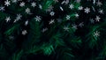 Sparkling snowflake bokeh lights on a dark evergreen background Royalty Free Stock Photo