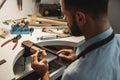 Delicate jewelry work. Close up of a male jeweler working and shaping an unfinished ring with a tool in workshop