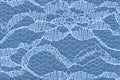 Delicate lace textured material on blue knit background Royalty Free Stock Photo