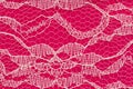 Delicate lace textured material on bright pink knit background Royalty Free Stock Photo