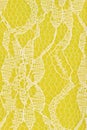 Delicate lace textured material on bright yellow knit background Royalty Free Stock Photo
