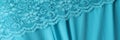 Delicate light blue guipure lace fabric on blue satin fabric