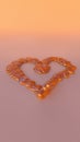 A Delicate Liquid Caramel Heart Candy on Light Peach Background