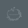 A delicate logo features a wreath made of botanical elements, including leaves and small flowers. Royalty Free Stock Photo