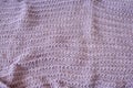 Delicate loose knitted mauve plaid with creative pattern close-up