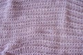 Delicate loose knitted mauve plaid with creative pattern close-up