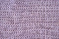 Delicate loose knitted mauve plaid with creative pattern close-up