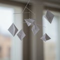 A delicate mobile featuring six geometric kite-shaped objects, crafted from white pap Royalty Free Stock Photo