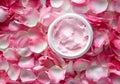 Open Jar of Luxurious Rose-Scented Cream Surrounded by Fresh Pink Petals Royalty Free Stock Photo