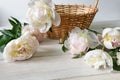 Delicate pale peonies on a white wooden table. Copy Space