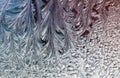 Delicate patterns of frost crystals on a sparkling glass