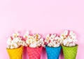 Delicate pink background and sweets. Sweet popcorn and colored waffles.