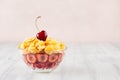 Delicate pink breakfast with golden corn flakes decorated cherry on white wood board. Decorative border with copy space. Royalty Free Stock Photo