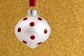 Delicate Red and White Glittery Christmas Ornament Hanging on a