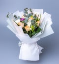 Delicate romantic bouquet of flowers wrapped in white paper. Royalty Free Stock Photo