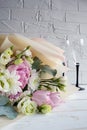 Delicate romantic bouquet for a gift. Huge pink peonies and white roses, two champagne glasses on a white background. Royalty Free Stock Photo