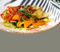 Delicate salad with ripe peach, cherry tomatoes, prosciutto, Parmesan cheese and honey-mustard sauce on gray background Royalty Free Stock Photo