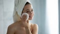 Content millennial woman using new facial sponge after shower
