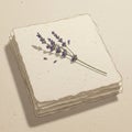 A delicate sprig of lavender (Lavandula) rests on a stack of textured, cream-colored Royalty Free Stock Photo
