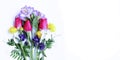 Delicate spring flower arrangement. Crimson tulips, white daffodils and lilac Alstroemeria flowers on a white background. Royalty Free Stock Photo