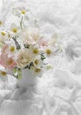 Delicate summer garden flowers in a jug on the table with a white airy tablecloth