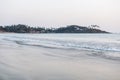 Delicate sunset over the ocean and beach with palm trees In Indid, Goa.