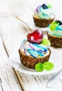 Delicate vanilla cupcakes with cream and berries on a white wooden background Royalty Free Stock Photo