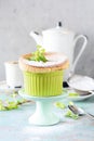 Delicate vanilla soufflÃÂ© in ramekin with icing sugar, hot coffee and fresh mint. Delicious French dessert to the coffee