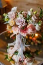 Delicate and very beautiful wedding bouquet of roses, greenery, eustoma standing on mirror table. Bridal trendy flowers
