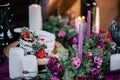 Delicate wedding white cake decorated with pomegranate and succulent surrounded by flowers and candles.