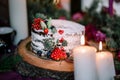 Delicate wedding white cake decorated with pomegranate and succulent surrounded by flowers and candles Royalty Free Stock Photo